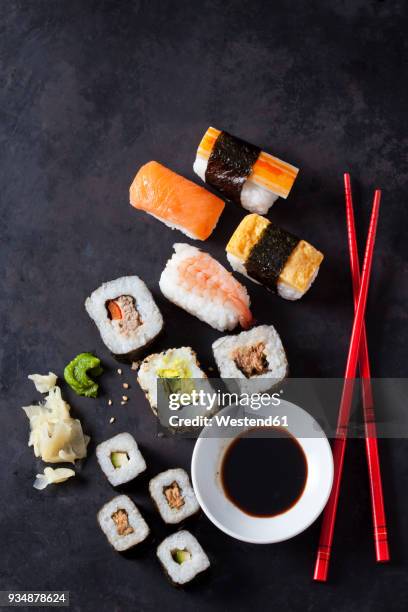 variety of sushi with wasabi, ginger and bowl of soy sauce on dark ground - fresh wasabi stockfoto's en -beelden