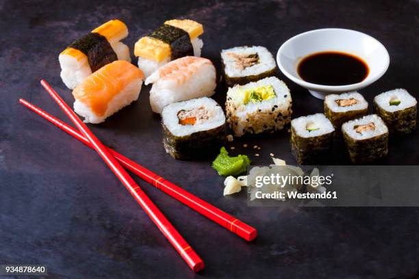 variety of sushi with wasabi, ginger and bowl of soy sauce on dark ground - fresh wasabi stockfoto's en -beelden