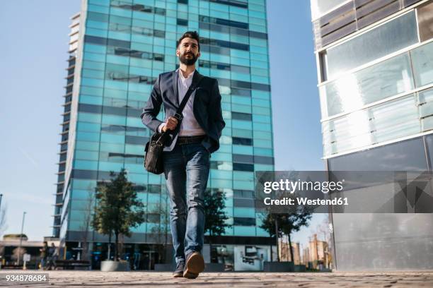businessman walking outside office building - dichterbij komen stockfoto's en -beelden
