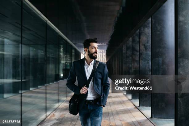 businessman walking along arcade - mirar alrededor fotografías e imágenes de stock