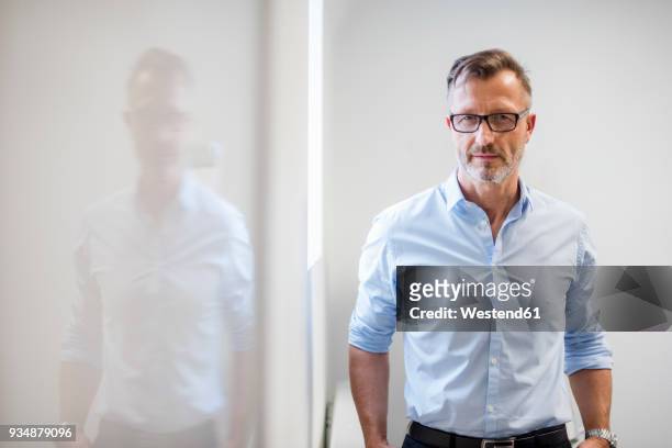 portrait of confident mature businessman in office - white shirt stockfoto's en -beelden