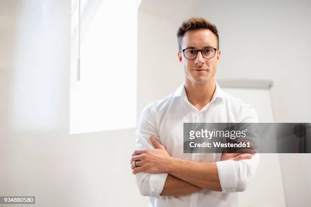 portrait of confident young businessman in office - smiling person white shirt stockfoto's en -beelden
