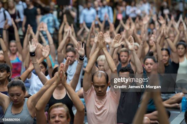 Sydneysiders take part in a mass yoga session on Pitt Street in Sydney's CBD during the evening rush hour on March 20, 2018 in Sydney, Australia. The...