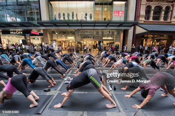 Sydneysiders take part in a mass yoga session on Pitt Street in Sydney's CBD during the evening rush hour on March 20, 2018 in Sydney, Australia. The...