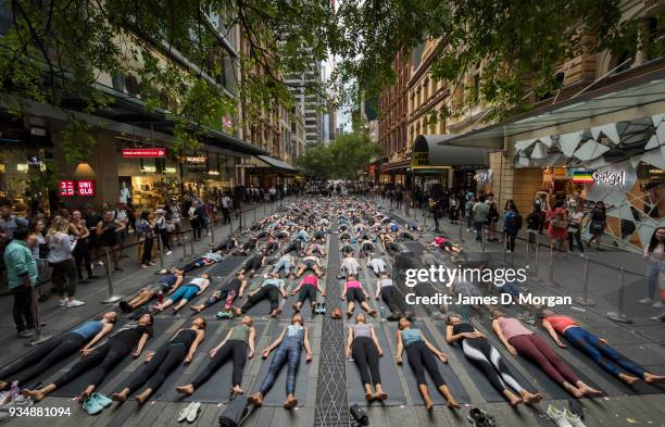 Sydneysiders take part in a mass yoga session on Pitt Street in Sydney's CBD during the evening rush hour on March 20, 2018 in Sydney, Australia. The...