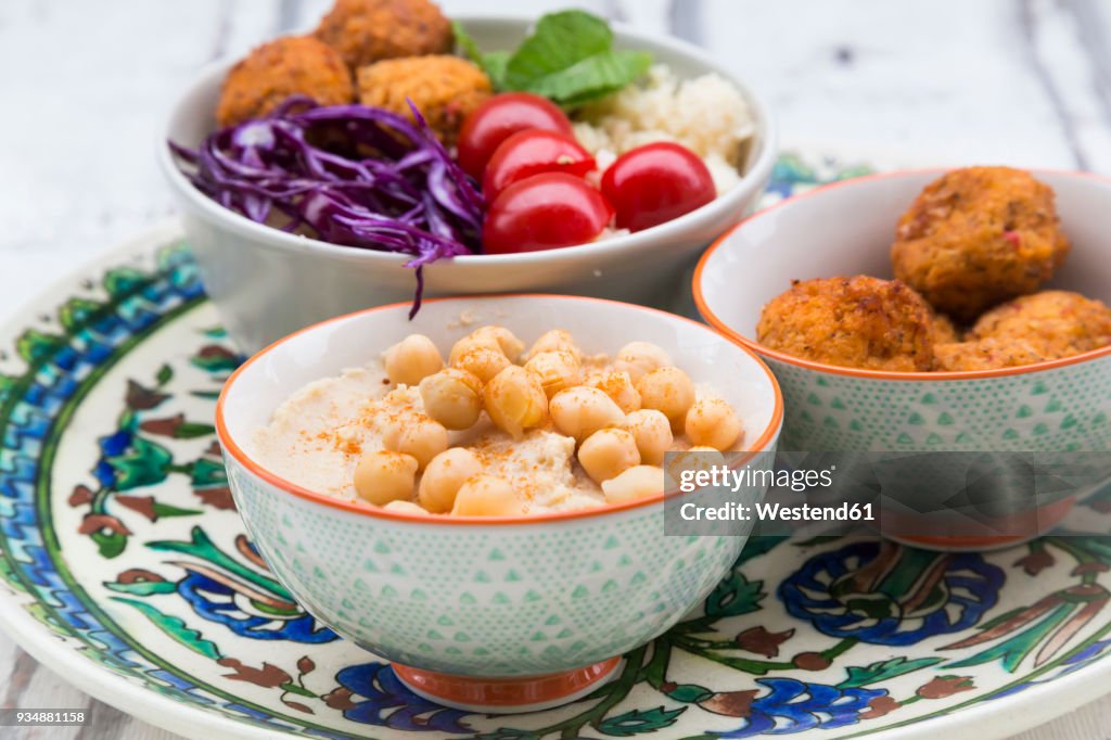 Hummus, sweet potato balls, Couscous and vegetables in bowls