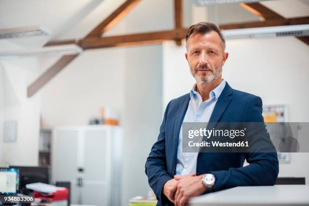 portrait of confident mature businessman in office - veste homme photos et images de collection