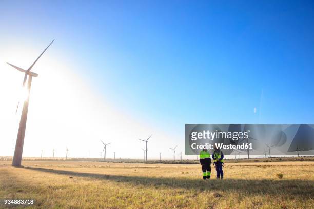 two engineers discussing on a wind farm - africa economy stock pictures, royalty-free photos & images