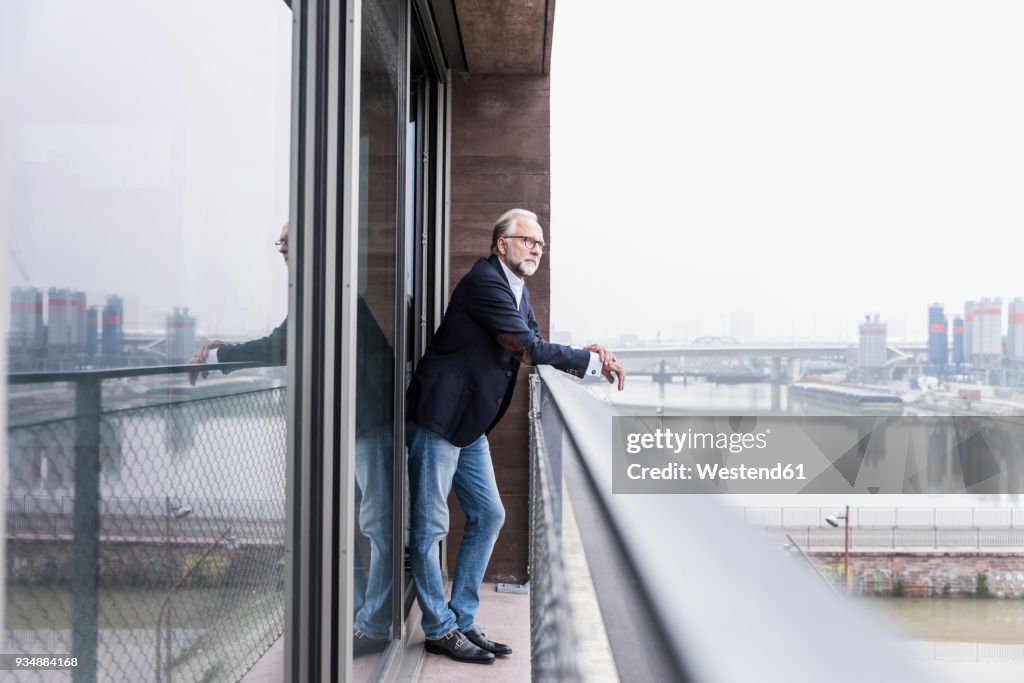 Mature businessman standing on balcony