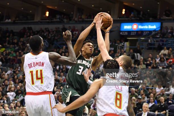 Giannis Antetokounmpo of the Milwaukee Bucks is defended by Dewayne Dedmon and Mike Muscala of the Atlanta Hawks during a game at the Bradley Center...