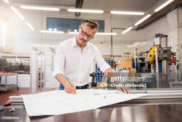 mature businessman in factory working on plan - 2018 blueprint stock pictures, royalty-free photos & images