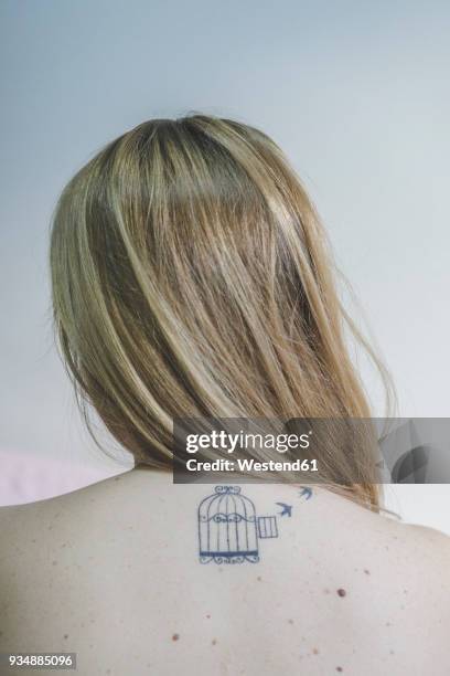 back view of blond woman with tattoo on her neck - tattoo shoulder stock pictures, royalty-free photos & images