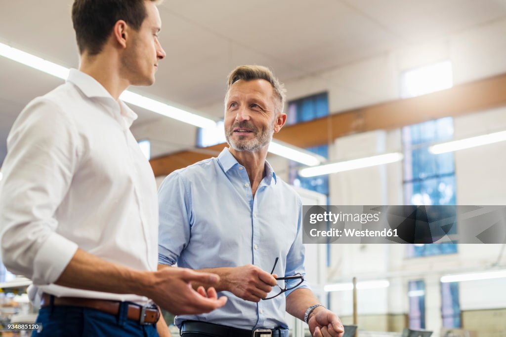 Two businessmen discussing in factory