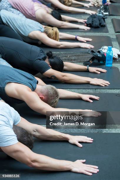 Sydneysiders take part in a mass yoga session on Pitt Street in Sydney's CBD during the evening rush hour on March 20, 2018 in Sydney, Australia. The...