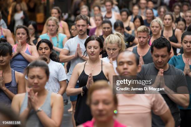 Sydneysiders take part in a mass yoga session on Pitt Street in Sydney's CBD during the evening rush hour on March 20, 2018 in Sydney, Australia. The...