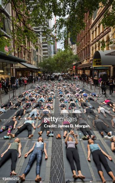 Sydneysiders take part in a mass yoga session on Pitt Street in Sydney's CBD during the evening rush hour on March 20, 2018 in Sydney, Australia. The...