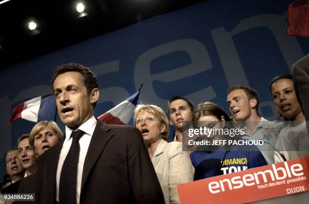 French right-wing presidential candidate Nicolas Sarkozy sing the national anthem at the end of a campaign meting, 23 April 2007 in Dijon, central...