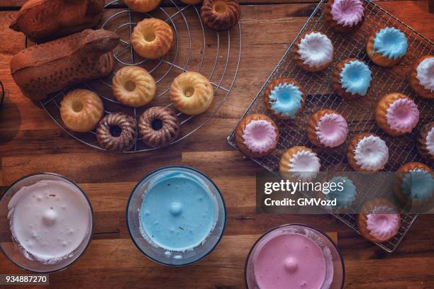 preparing small easter bunt cakes with sweets and icing - bunt cake stock pictures, royalty-free photos & images