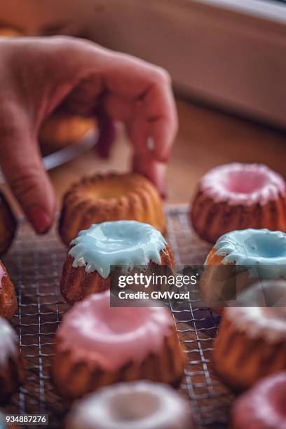 preparing small easter bunt cakes with sweets and icing - bunt cake stock pictures, royalty-free photos & images