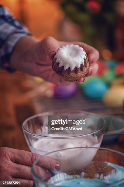 preparing small easter bunt cakes with sweets and icing - bunt cake stock pictures, royalty-free photos & images