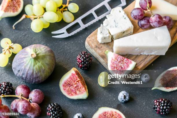 plate with cheese, figs, grapes, blueberries, brambles, pecan, chopping board, knife - gorgonzola stock pictures, royalty-free photos & images