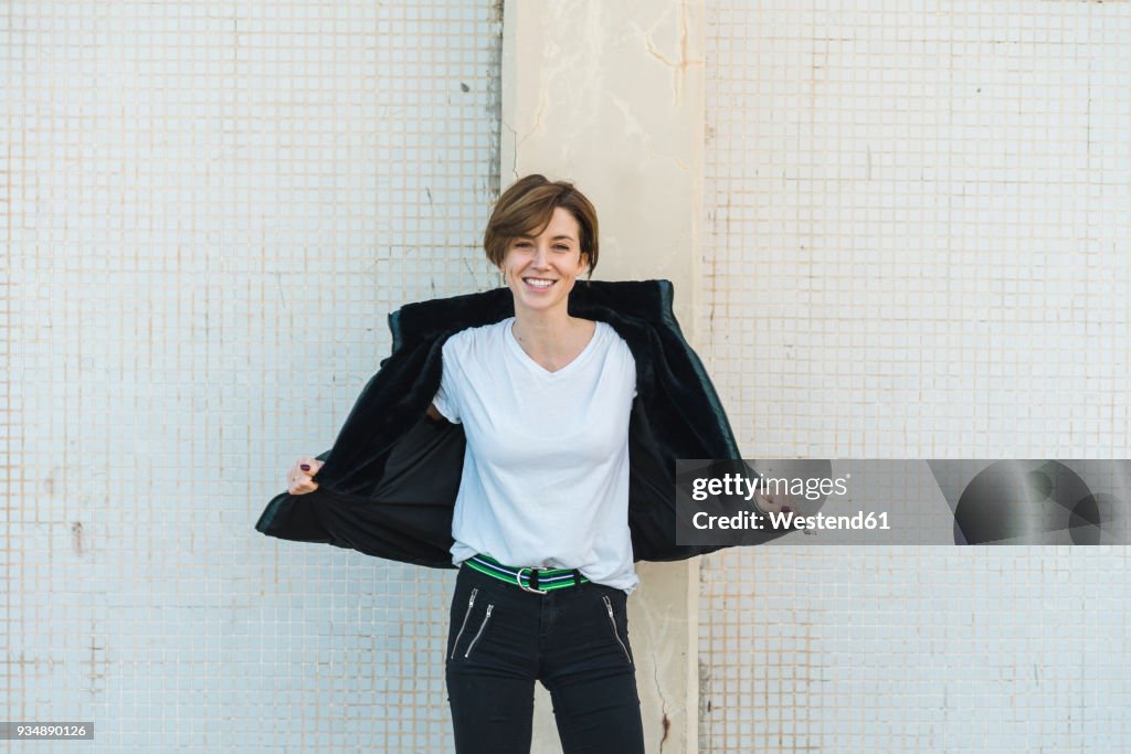 Portrait of relaxed woman taking off her jacket