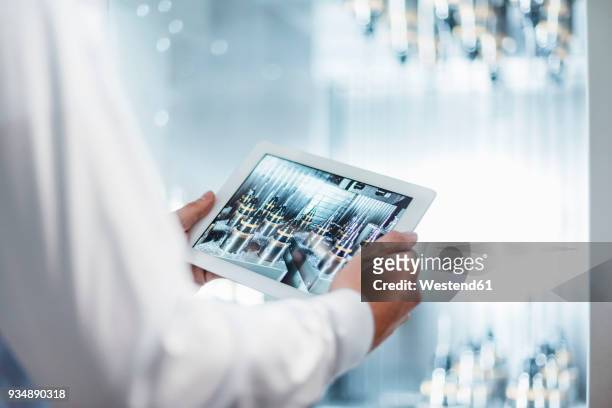 close-up of man holding tablet at machine in factory - ipad industrie stock-fotos und bilder
