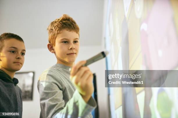 students in class at interactive whiteboard - interaktives whiteboard stock-fotos und bilder