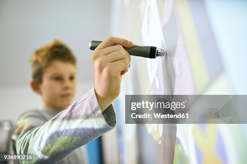 Student in class using digitized pen at interactive whiteboard Student in class using digitized pen at interactive whiteboard