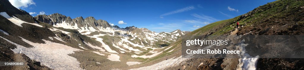 A person walking alone on a remote mountain trail