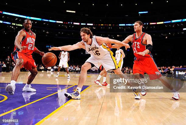 Pau Gasol of the Los Angeles Lakers reaches for a the ball against Brook Lopez and Bobby Simmons of the New Jersey Nets during the second quarter of...