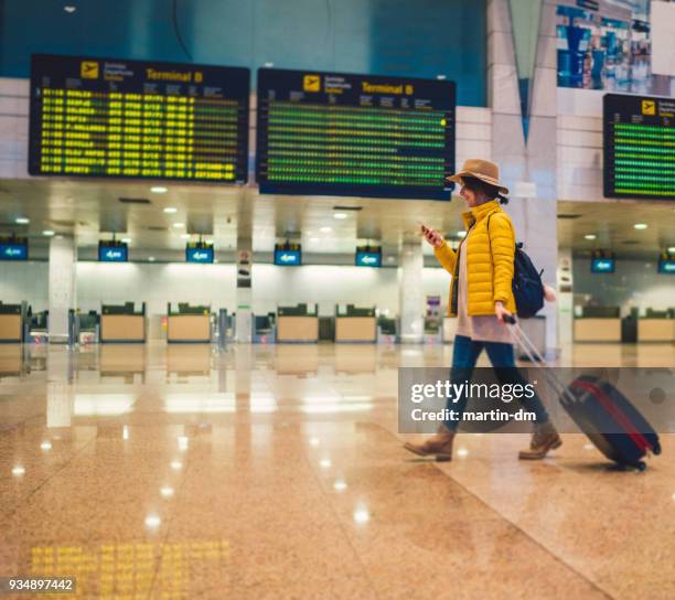mujer joven con smartphone en la terminal del aeropuerto - heathrow airport fotografías e imágenes de stock