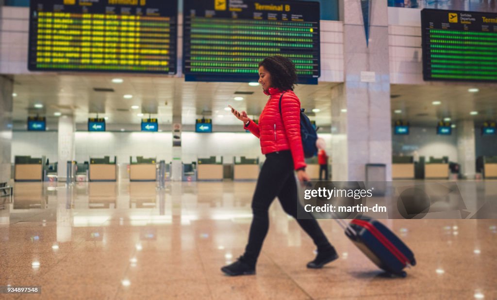 Mensajes de mujer de raza mixta en la terminal del aeropuerto