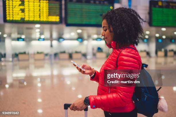 gemengd ras toeristische vrouw controleren voor vlucht op de luchthaven - charles de gaulle airport stockfoto's en -beelden