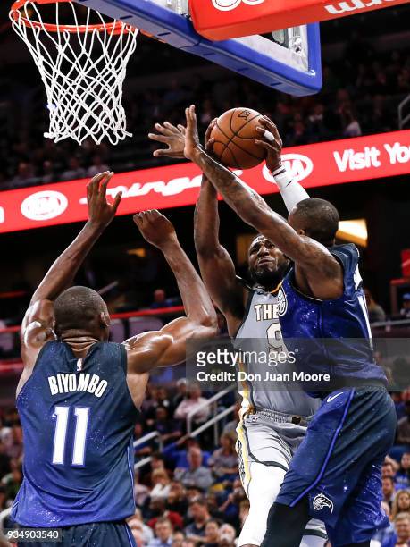Jae Crowder of the Cleveland Cavaliers goes up to the basket against Bismack Biyombo and Jonathon Simmons of the Orlando Magic during the game at the...