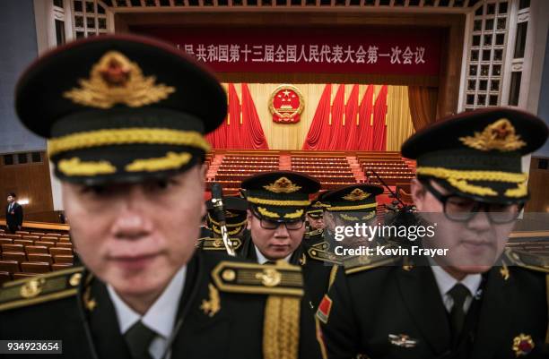 Members of a band from the People's Liberation Army leave following a speech by China's President Xi Jinping after the closing session of the...