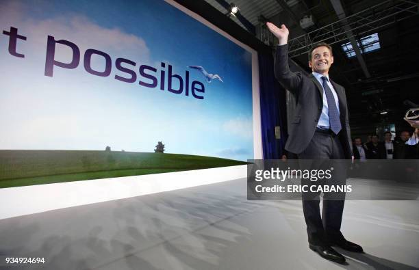 French right-wing presidential candidate Nicolas Sarkozy waves to the crowd as he arrives on stage to deliver a speech during a meeting, in Toulouse,...