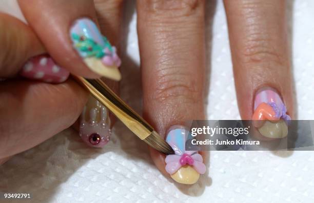 Nail artist adds the final touch to her nails during the Tokyo Nail Expo 2009 at Tokyo Big Sight on November 30, 2009 in Tokyo, Japan. The nail...