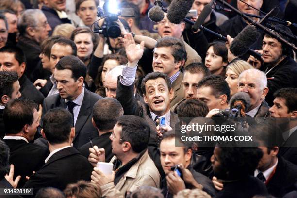 French Interior Minister and right-wing presidential candidate Nicolas Sarkozy , surrounded by journalists, waves to the public as he visits the...