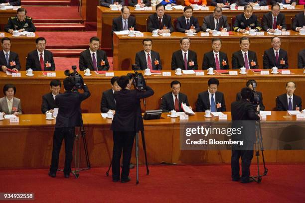 Cameramen stand in front of Zhang Gaoli, China's former vice premier, second row from left, Zhang Dejiang, former chairman of the Standing Committee...