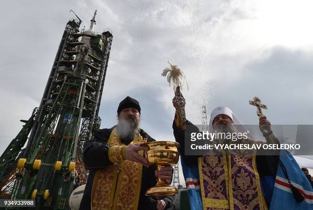 Russian Orthodox priest conducts a blessing in front of the Soyuz MS-08 spacecraft set on the launch pad of the Russian-leased Baikonur cosmodrome in...