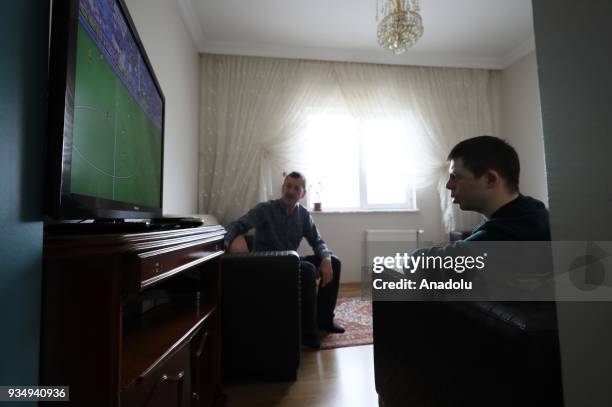 Year-old man with down syndrome Cengizhan Donmez watches TV at his home after work in Ankara, Turkey on March 20, 2018. Donmez who won bronze medal...