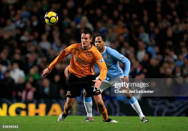 Jan Vennegoor of Hesselink of Hull City watches the ball ahead of Joleon Lescott of Manchester City during the Barclays Premier League match between...