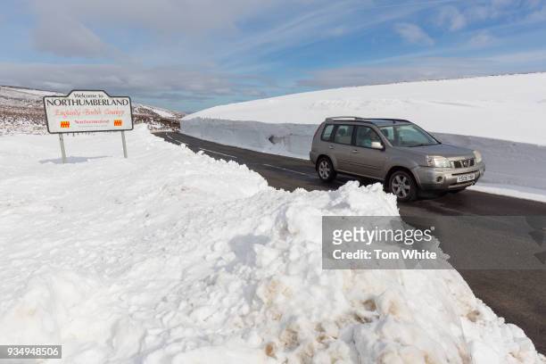 Car is surrounded by deep snow as it makes its way along a road in the Pennines on March 20, 2018 in Allenheads, England. Winter conditions are...