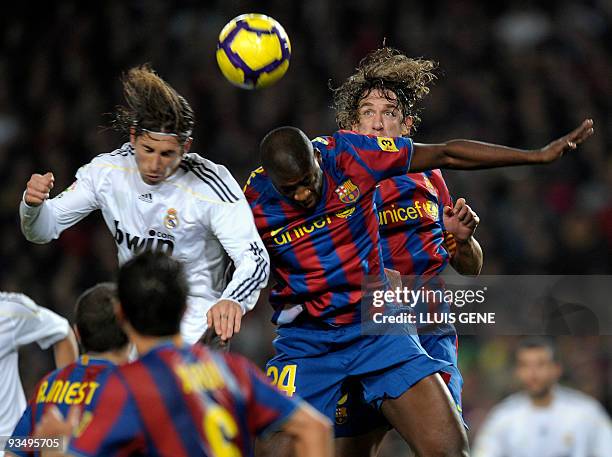 Real Madrid's defender Sergio Ramos vies with Barcelona's midfielder from Ivory Coast Yaya Toure and captain Carles Puyol during their Spanish League...