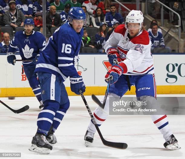 Jacob de la Rose of the Montreal Canadiens fires a puck past a checking Mitchell Marner of the Toronto Maple Leafs during an NHL game at the Air...