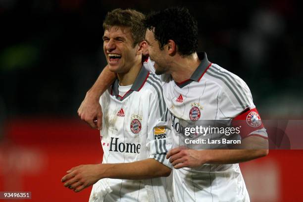 Thomas Mueller of Muenchen jokes with Mark van Bommel after winning the Bundesliga match between Hannover 96 and FC Bayern Muenchen at AWD-Arena on...