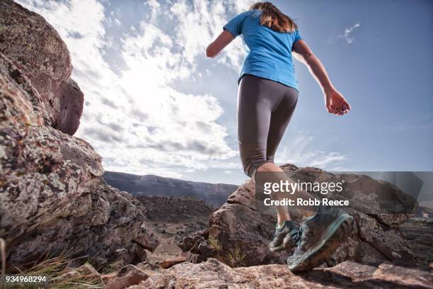an adult woman trail running on a remote dirt trail - robb reece stockfoto's en -beelden