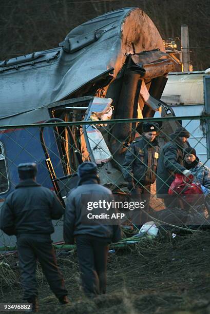 Experts inspect the debris of a damaged railway carriage near the village of Uglovka in Russia's Novgorod region on November 28 after a train...