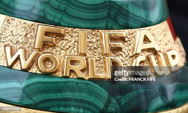 Picture taken on March 20, 2018 shows a detail of the 2018 FIFA World Cup trophy during the FIFA World Cup Trophy Tour on in Paris. The 2018 FIFA...